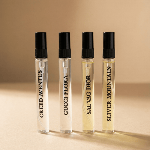 Four perfume bottles with black caps on a beige background